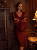 Aliza standing in a dimly lit room with her arms crossed modeling the Vamp pencil skirt in oxblood.