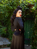 Micheline Pitt turned away from the camera while turning her head to look back while modeling the Salem Top in Black.