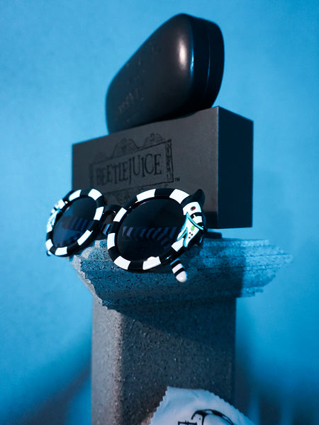 Isolated shot of the BEETLEJUICE™ Sandworm Spectacles on a stone pedestal.
