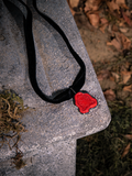 Perched on a tombstone, a detailed closeup of the Sleepy Hollow™ Van Garrett Wax Seal Necklace by La Femme En Noir.