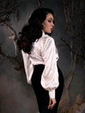Micheline Pitt standing in a foggy, forest setting while wearing the Victorian Blouse in Ivory - a gothic style shirt with flowy sleeves.