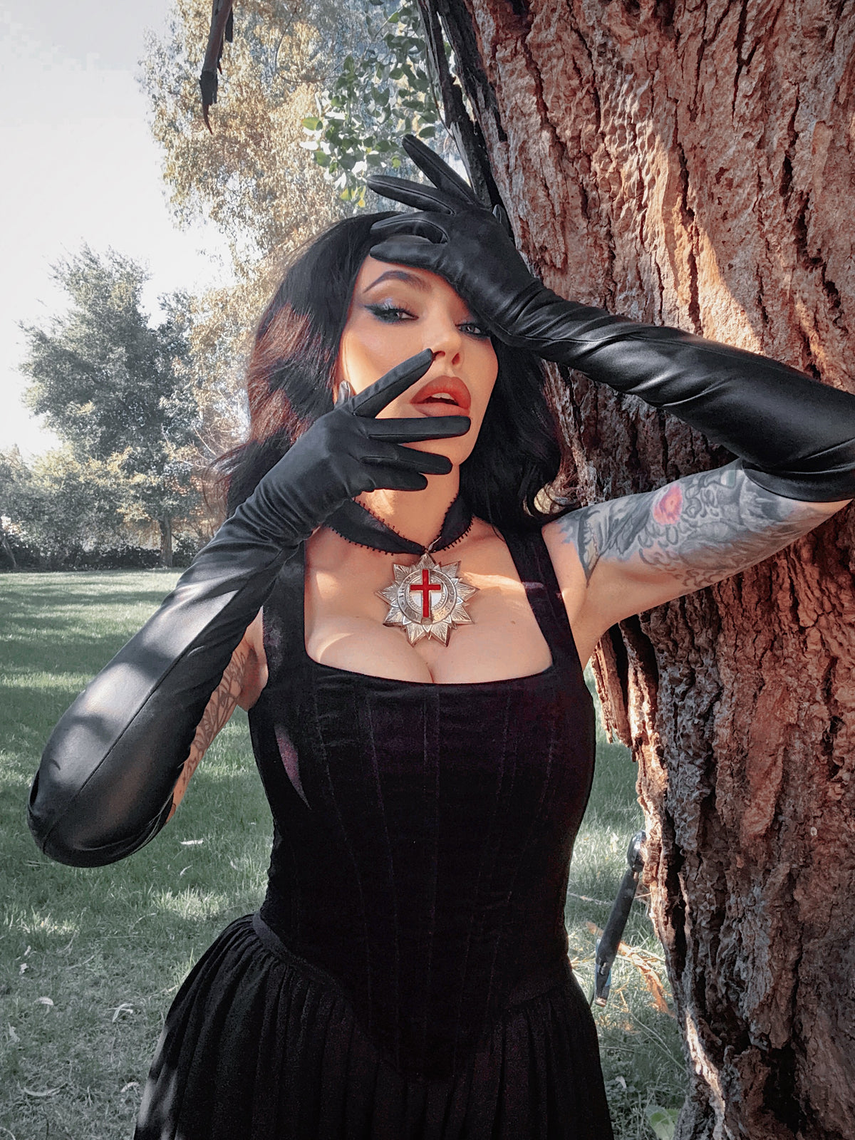 A gloved hand held in a dramatic, theatrical pose, evoking the timeless allure of a vintage film noir starlet with a gothic twist.