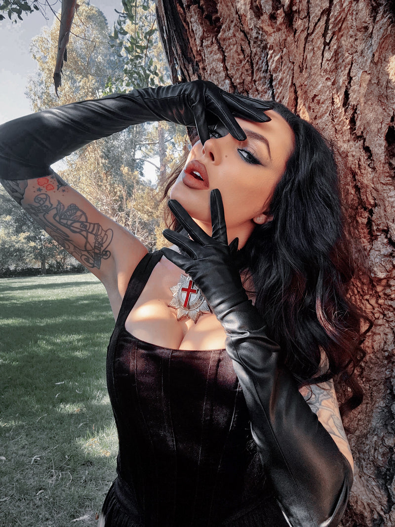 A model adjusts a veil while wearing the opera gloves, a hauntingly beautiful image that captures the essence of dark romance.