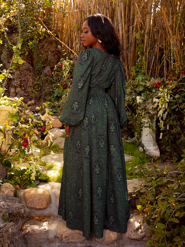 The dress is styled against a moody, dramatic backdrop, perfect for a formal event or dark romantic evening vibe.