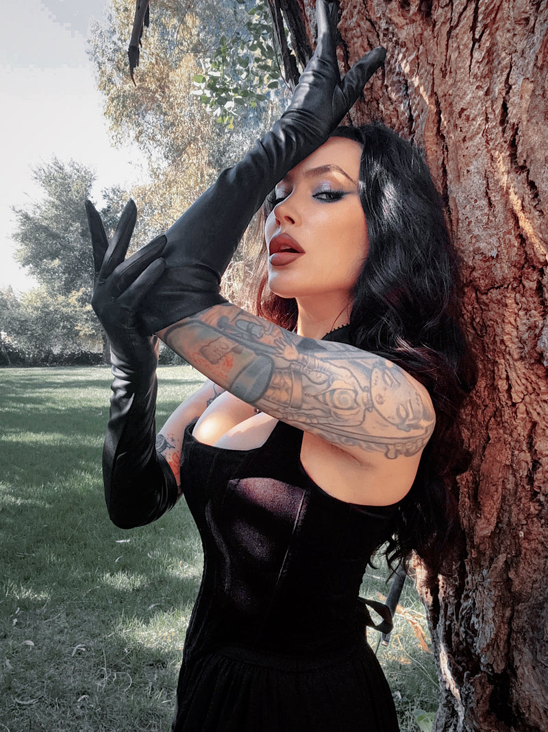 Ornate silver rings are worn over the black faux leather, a striking Whimsigoth detail that merges occult charm with dark glamour.