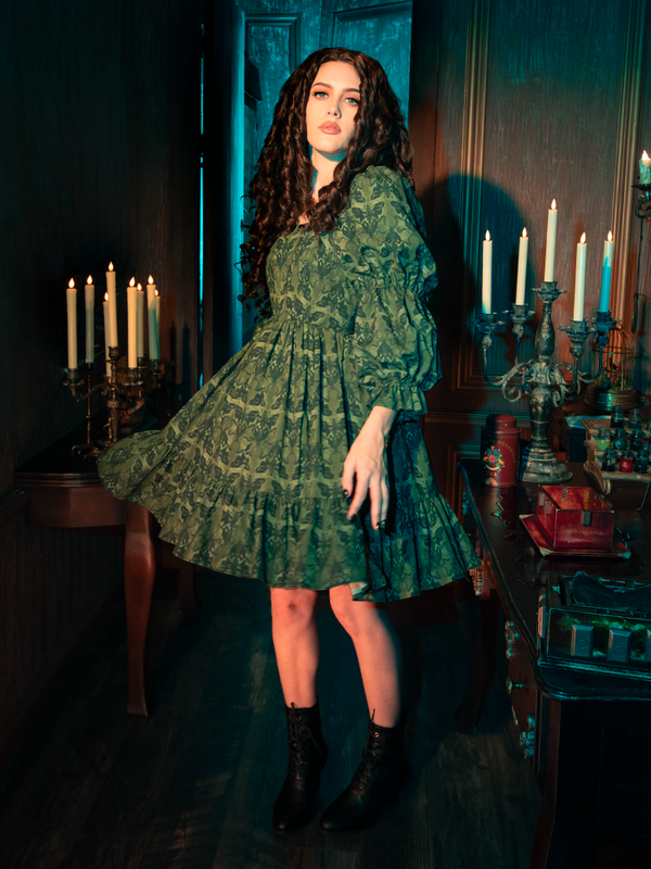 Wrapped in the Allerdale Moth Wallpaper Babydoll Dress, you are an embodiment of the eternal night. The olive fabric, as deep and mysterious as the forest at midnight, is adorned with moths that navigate by the moon's glow. This dress is a celebration of the unseen, the untold, and the unforgettable.