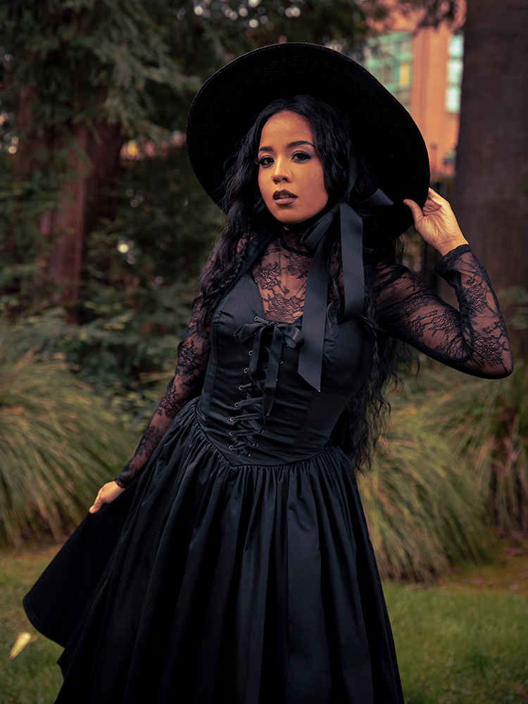 Ethereal lace meets gothic strength in the Lace Base Top in Black, a versatile piece that whispers elegance when layered or worn on its own.