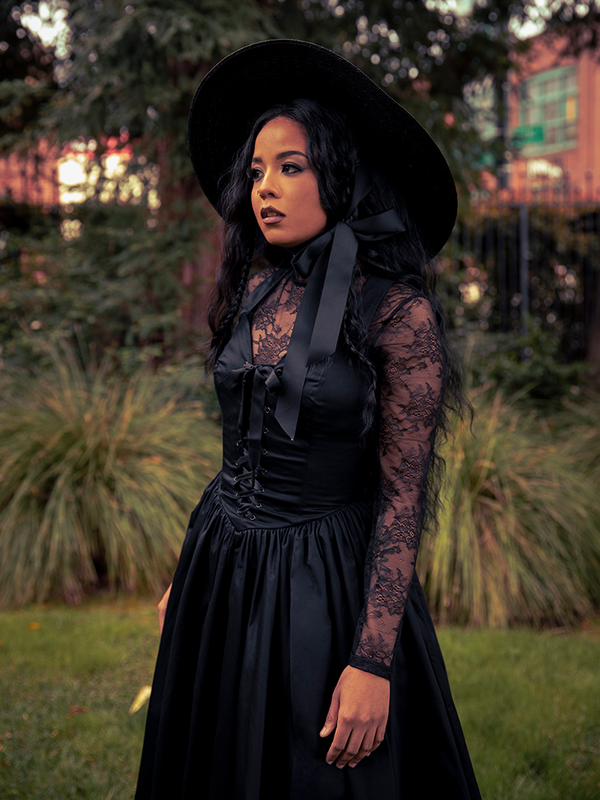 The Lace Base Top in Black dances between light and shadow—its lace detailing capturing the essence of gothic femininity, alluring and unforgettable