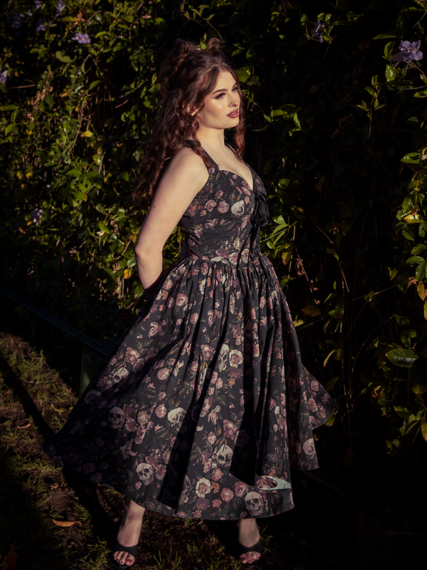 Against a dark tapestry of tangled flora, the Ambrosia Dress blooms—decadent, melancholic, and utterly enchanting in its faded floral spell.