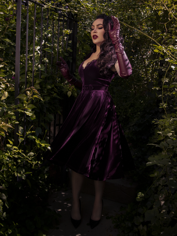 A side view of the dress emphasizing the nipped-in waist and dramatic skirt volume.