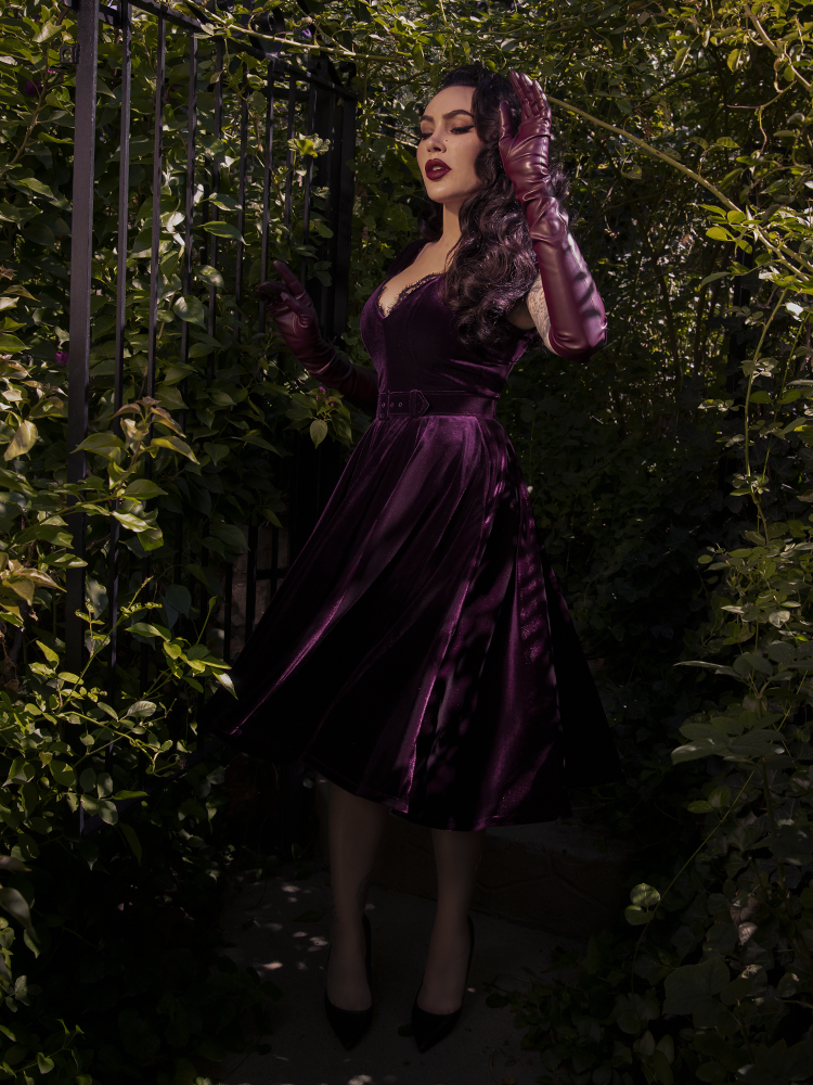 A side view of the dress emphasizing the nipped-in waist and dramatic skirt volume.