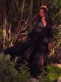 Surrender to the dark enchantment of the Belladonna Maxi Dress in Black. This captivating dress, with its graceful silhouette and deep black hue, embodies gothic glamour. Perfect for evening affairs or twilight walks, it envelops you in a timeless, elegant embrace.