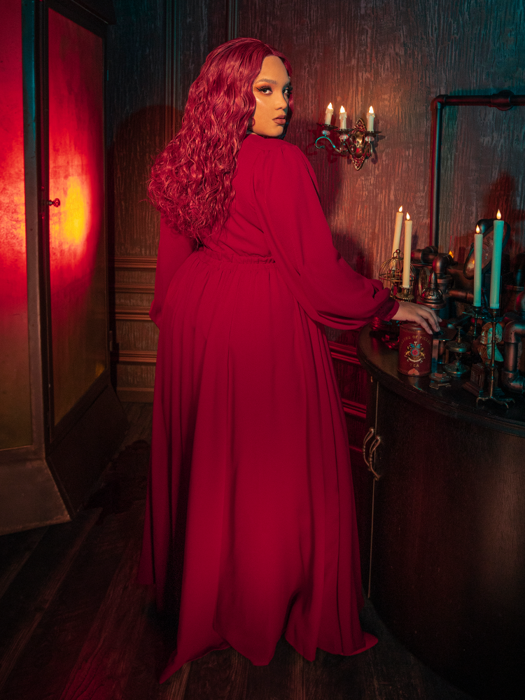 Portrait of a model in the Belladonna red maxi dress, focusing on the buttoned cuffs and the structured yet soft georgette fabric that defines gothic glamour women's wear.