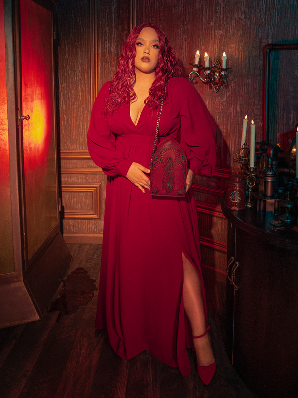 Close-up of the faux wrap bodice and deep V-neckline of the Belladonna dress in crimson, emphasizing the romantic, feminine draping typical of luxury gothic glamour.