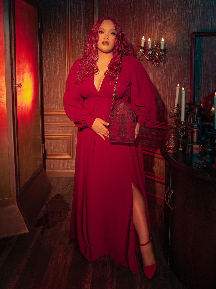 Close-up of the faux wrap bodice and deep V-neckline of the Belladonna dress in crimson, emphasizing the romantic, feminine draping typical of luxury gothic glamour.