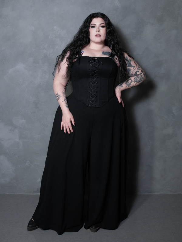 A female model commands attention in an exquisite piece of gothic glamour clothing, wearing a deep black structured corset.