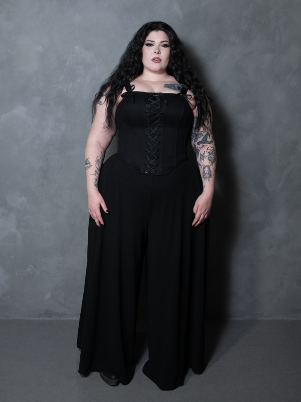 A female model radiates absolute dark elegance and high-fashion mystery, wearing a black cotton sateen corset.
