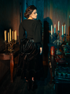Step into the shadows with models showcasing the hauntingly gorgeous Victorian Velvet Bustle Skirt in Black, a masterpiece from the gothic clothing brand La Femme en Noir.
