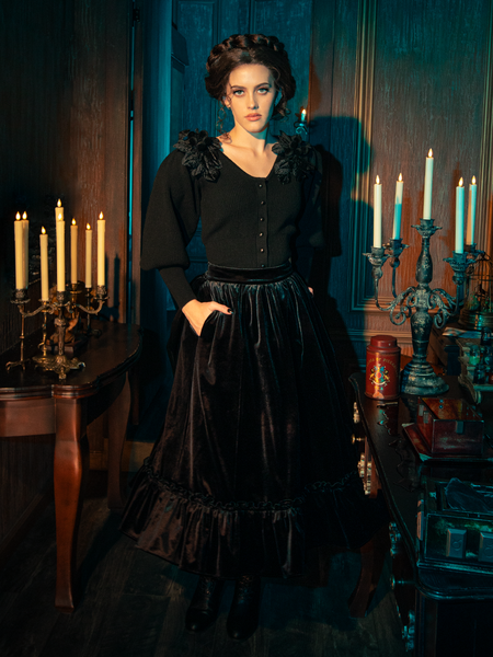 Embrace the dark elegance with models presenting the hauntingly gorgeous Victorian Velvet Bustle Skirt in Black from the gothic clothing brand La Femme en Noir.