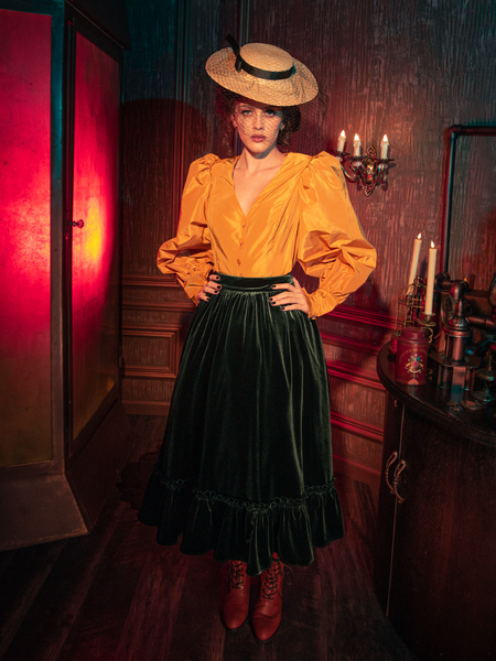 Embark on a journey into gothic fashion with models presenting the hauntingly gorgeous Victorian Velvet Bustle Skirt in Olive from La Femme en Noir.