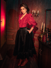 The captivating allure of La Femme en Noir's Victorian Velvet Bustle Skirt in Black is brought to life by models in a hauntingly gorgeous fashion.
