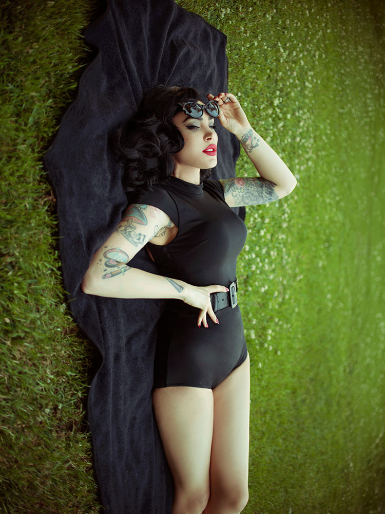 Female model styled with the Coffin Cotton Beach Towel in Black, highlighting moody statement accessories and occult elegance.
