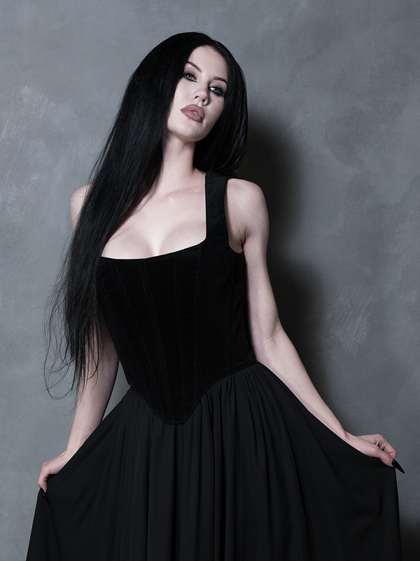 A model in a poised, elegant stance highlighting the seamless paneling and reinforced stitching of this exquisite black velvet garment.