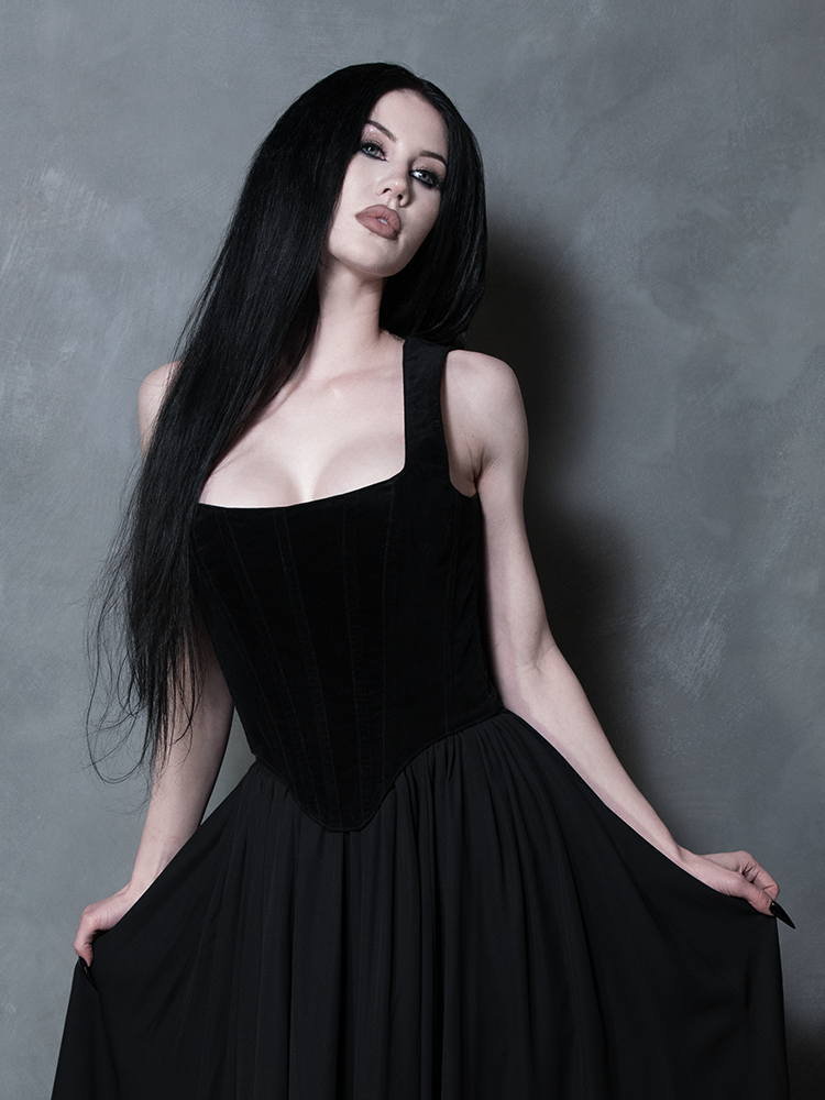 A model in a poised, elegant stance highlighting the seamless paneling and reinforced stitching of this exquisite black velvet garment.