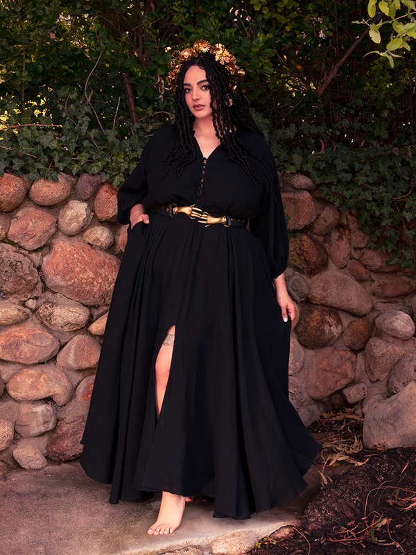 A slit reveals power in this gothic dress — both demure and dangerously divine.

