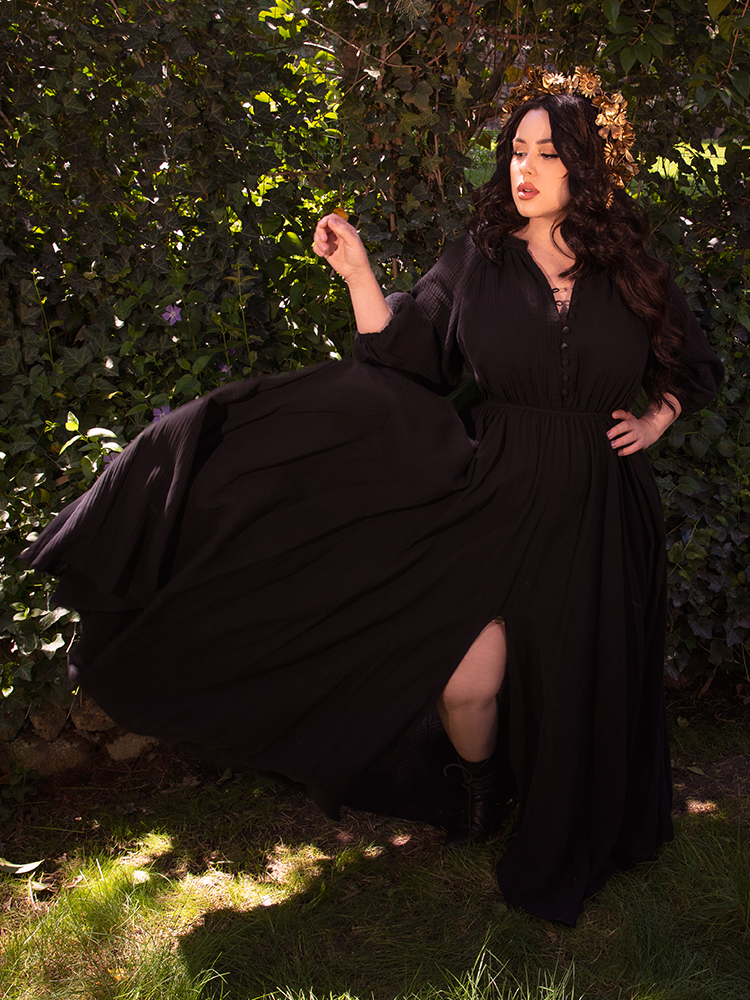 She drifts down a candlelit hallway, the dress whispering secrets with every graceful step.