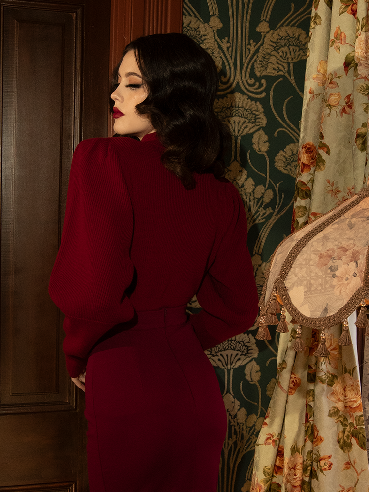 Timeless and fierce, this crimson cycling sweater’s intricate details and high neckline evoke the elegance of Victorian fashion with a bold, modern edge.

