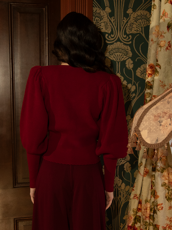 A whisper of old-world romance, this crimson knit cardigan features soft, breathable fabric, bishop sleeves, and a high-neck design for an elegant gothic touch.

