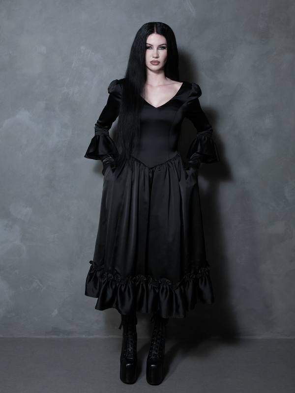 Radiating pure gothic glamour, a female model brings a hauntingly beautiful black satin romance gown to life.