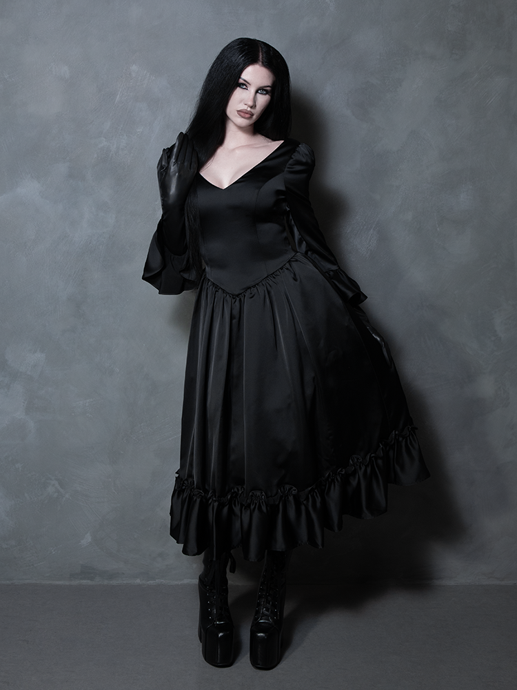Wrapped in luxury and dark romance, a female model displays an absolute vision of gothic glamour in a black satin dress.