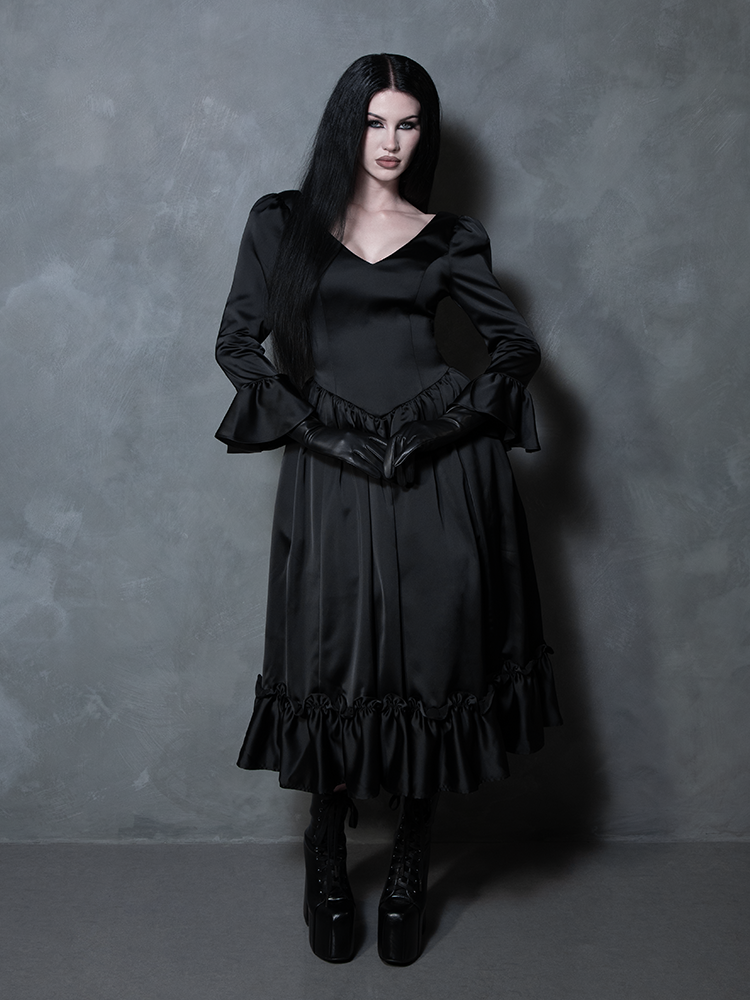 Swept up in an aura of dark romance, a female model beautifully represents the spirit of high-end gothic clothing in a black dress.