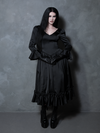 Swept up in an aura of dark romance, a female model beautifully represents the spirit of high-end gothic clothing in a black dress.