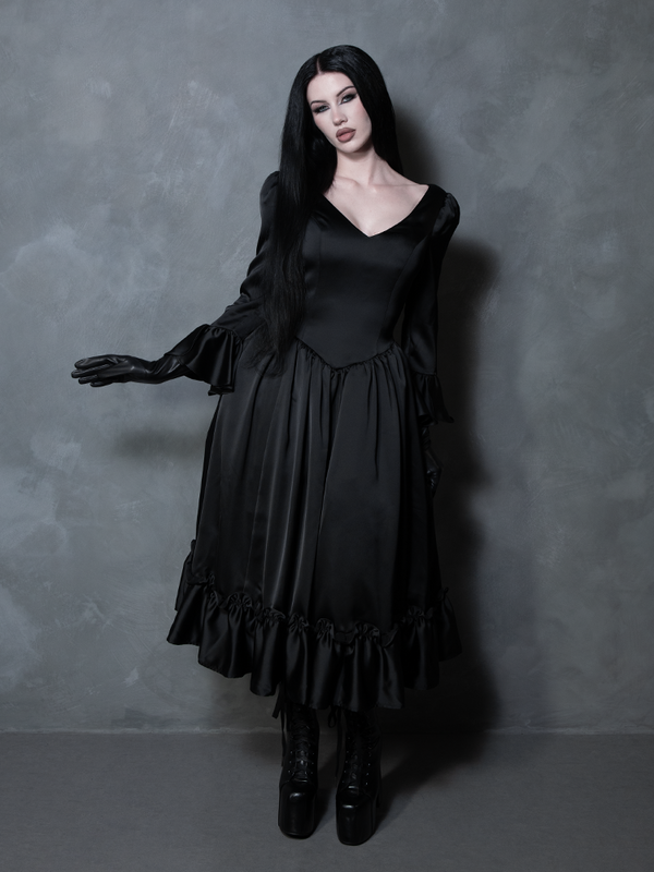 A female model captures the classic essence of midnight beauty in an enchanting black satin gothic clothing masterpiece.