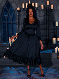 Draped in the haunting candlelight's embrace, the beguiling maiden dons the Velvet Whispers of Midnight Bustier Gown, a masterpiece from the gothic enigma known as La Femme en Noir.