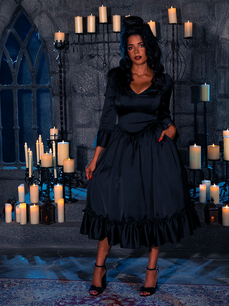 Concealed within a chamber bathed solely in the spectral glow of candles, the bewitching siren presents the Midnight Reverie Silk Bustier Robe, a creation of the eminent gothic artistry that is La Femme en Noir.