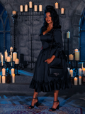 Surrounded by the spectral glow of candle flames, the captivating enchantress parades the Darkened Obsession Silk Bustier Robe, a creation of the enigmatic gothic artistry, La Femme en Noir.
