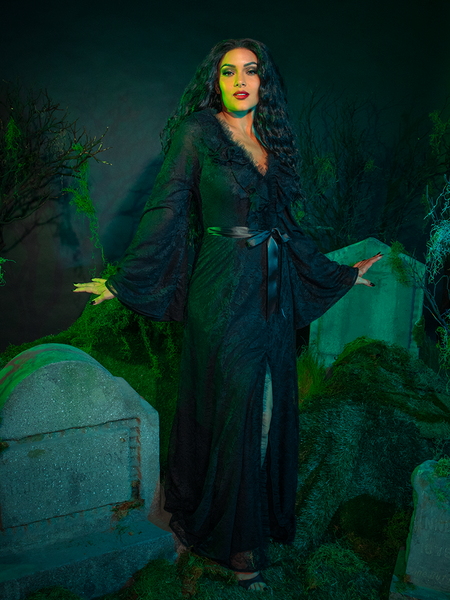 Drape yourself in dark enchantment with the Beetlejuice™ Delores Dress. Its cascading black lace evokes a ghostly allure, while the dramatic sleeves and high collar whisper of gothic elegance. A hauntingly beautiful choice for moonlit revelry or spectral soirées.