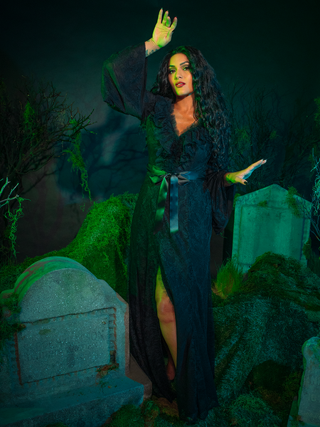 A gothic romance woven in shadows, the Beetlejuice™ Delores Dress captivates with its intricate black lace and classic Victorian-inspired design. The delicate bell sleeves and corseted waist offer a bewitching silhouette, ideal for a night of dark glamour.