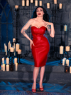 Micheline Pitt sets the mood in a candle-lit dungeon while showcasing the edginess of gothic clothing with the BRAM STOKER'S DRACULA Quilted Order of the Dragon Armor Skater Skirt in Blood Red Vegan Leather, a standout piece from La Femme en Noir's collection.