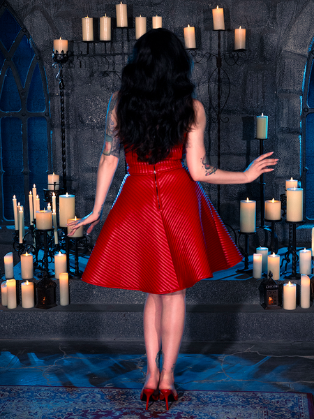 In a dungeon bathed in candlelight, Micheline Pitt epitomizes gothic style with her choice of the BRAM STOKER'S DRACULA Quilted Order of the Dragon Armor Skater Skirt in Blood Red Vegan Leather, a creation by La Femme en Noir.
