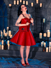 Micheline Pitt sets the mood in a candle-lit dungeon while wearing the BRAM STOKER'S DRACULA Quilted Order of the Dragon Armor Skater Skirt in Blood Red Vegan Leather, a striking piece from the gothic clothing brand La Femme en Noir.