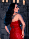 Donning the BRAM STOKER'S DRACULA Quilted Order of the Dragon Armor Bustier Top in Blood Red Vegan Leather, Micheline Pitt embraces the ambiance of a candle-lit dungeon, embodying the allure of gothic clothing, courtesy of La Femme en Noir.