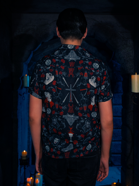 The BRAM STOKER'S DRACULA Button Up Short Sleeve Shirt in Dracula Novelty Print is on display as the model strikes a pose in the candlelit dungeon.