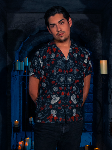 In a candle-lit dungeon, the model elegantly showcases the BRAM STOKER'S DRACULA Button Up Short Sleeve Shirt in Dracula Novelty Print.