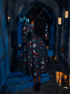 In the haunting ambiance of a dim dungeon, an exquisite model brings the BRAM STOKER'S DRACULA Gothic Tales Swing Dress in Dracula Novelty Print by La Femme en Noir to life.