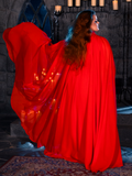 In a dimly lit dungeon, a female model showcases her elegant style with the BRAM STOKER'S DRACULA Lucy Bustier Gown and Matching Cape in Fire Orange, a captivating ensemble from the goth clothing brand La Femme en Noir.